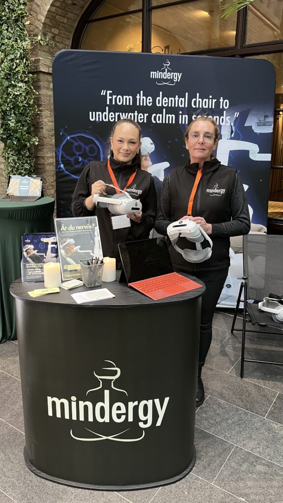 An image of two colleagues participating in a swedish dental conference standing in their place holding vr headsets